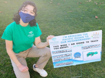 Kid with sign educating people about the ocean